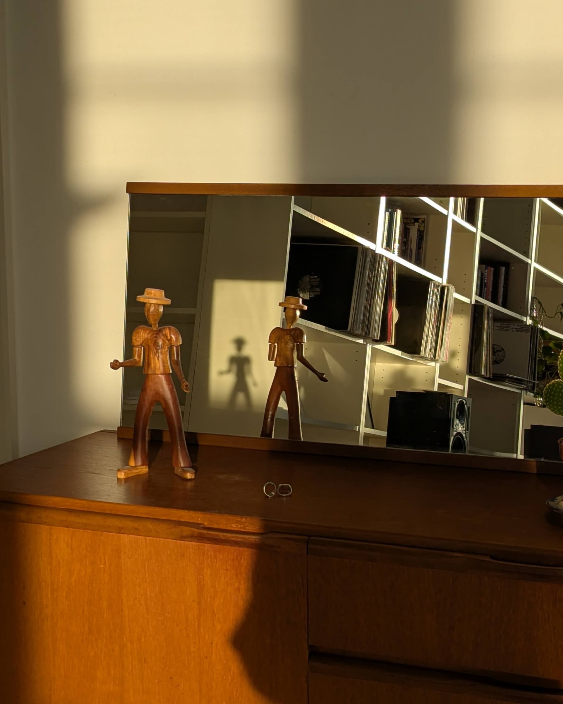 Wooden sculpture on sideboard with mirror